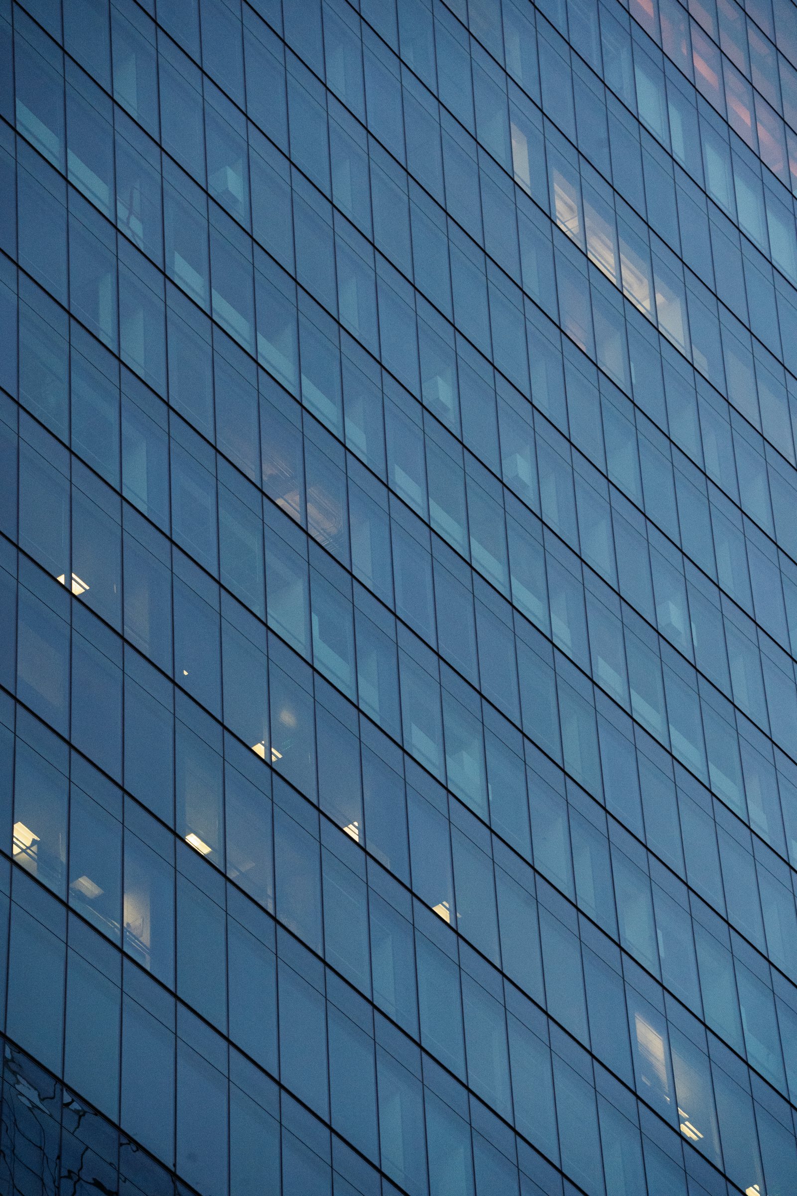 Blue glass facade of a modern financial-district office building