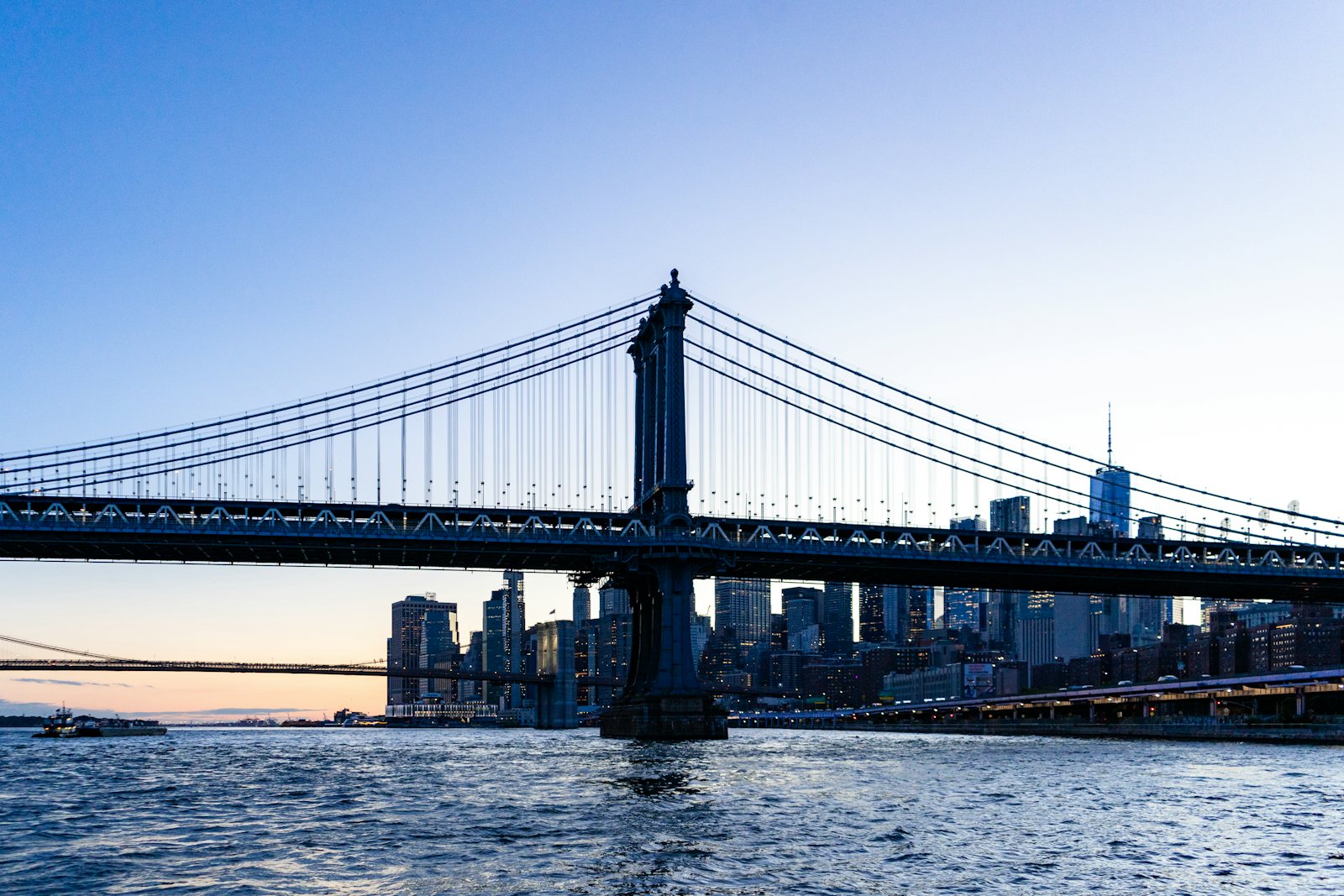 A bridge and city financial-district skyline at dusk